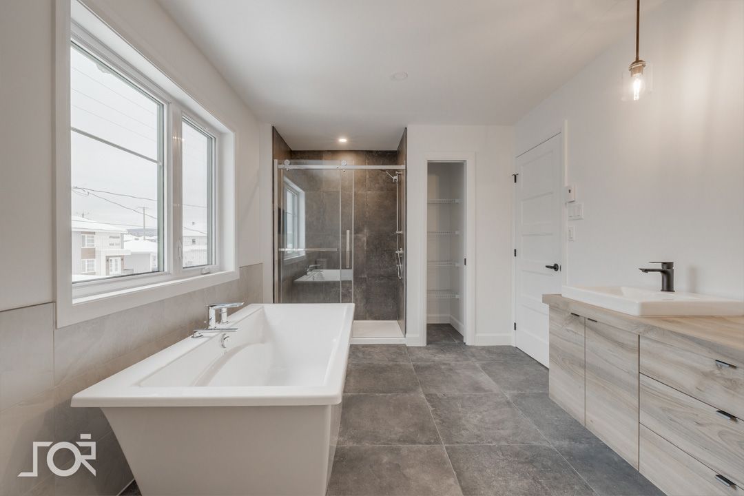 Une salle de bain avec baignoire, lavabo et douche.