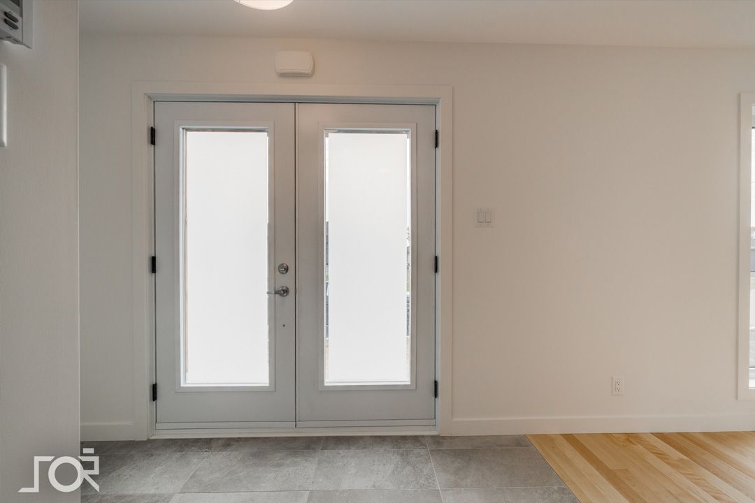 Une pièce vide avec une porte blanche et la lettre r sur le mur