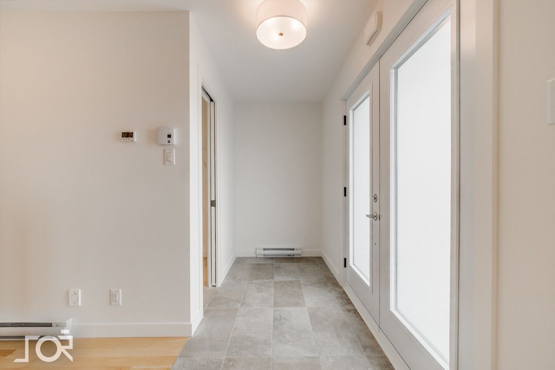 Un couloir vide avec une porte et une lumière au plafond