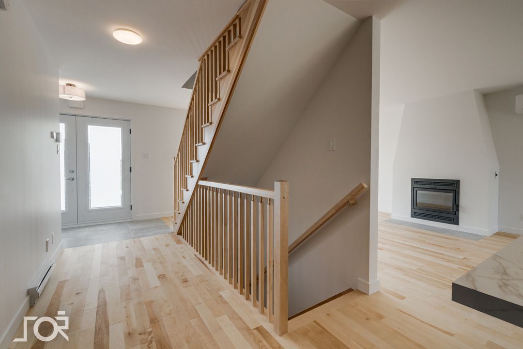 Un escalier avec une rampe en bois dans une maison vide