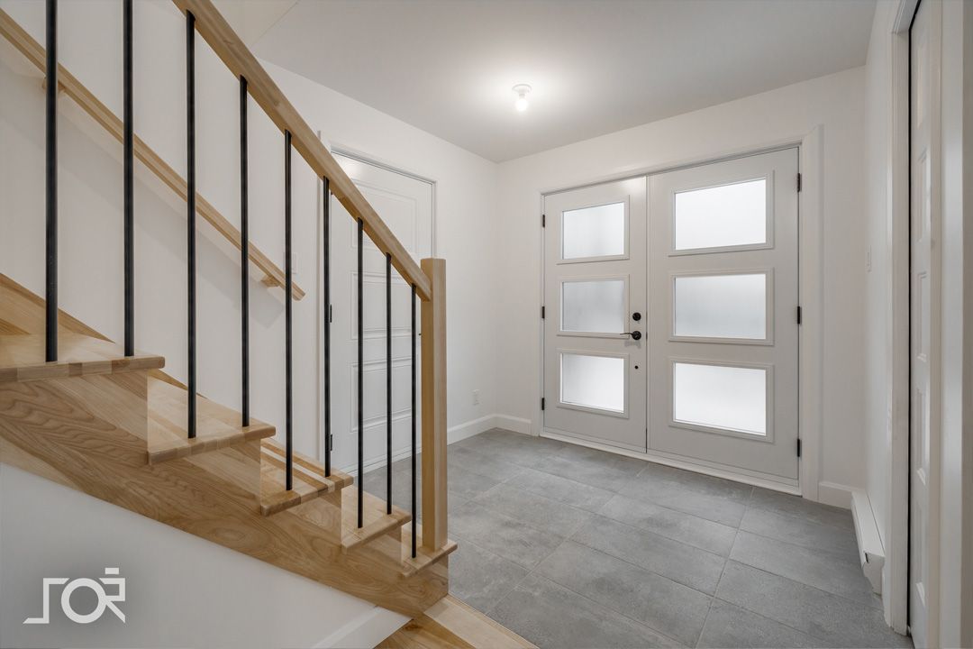 Un couloir vide avec des escaliers et une porte