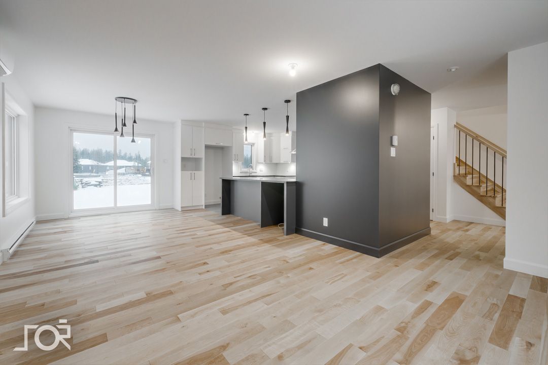 Une pièce vide avec du parquet et un escalier