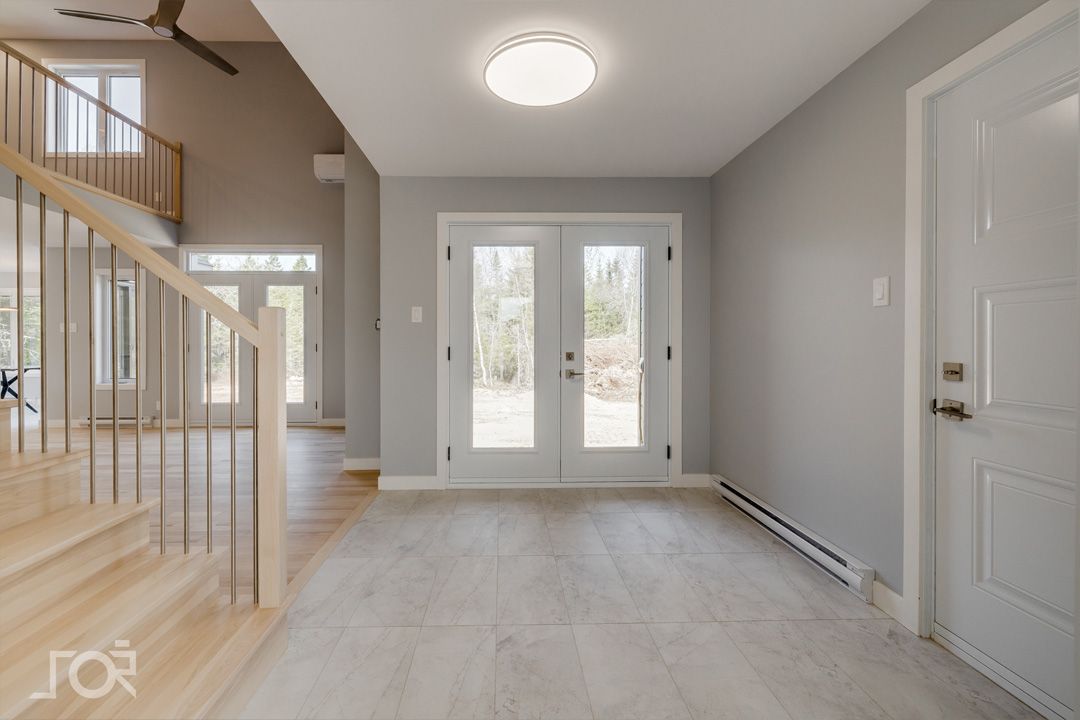 Un couloir vide avec des escaliers et une porte blanche