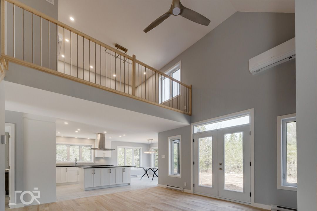 Une maison vide avec un balcon et un ventilateur de plafond.