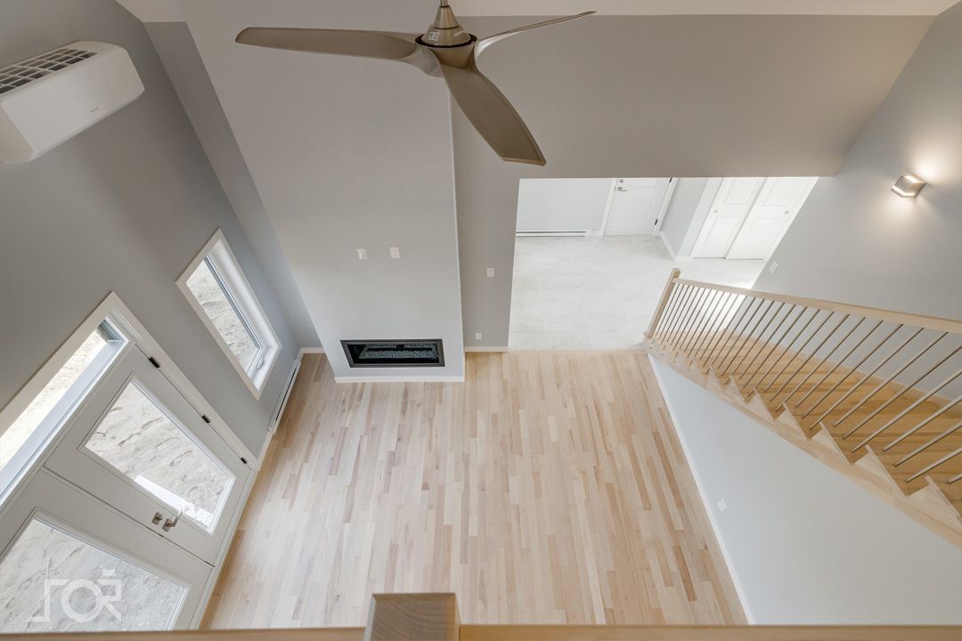 Une vue aérienne d'un salon avec parquet et ventilateur de plafond.