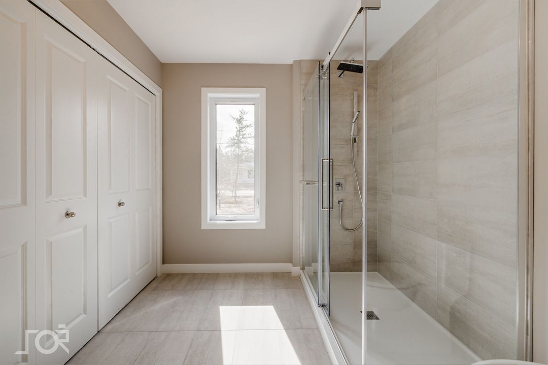 Une salle de bain avec une douche à l'italienne et une fenêtre