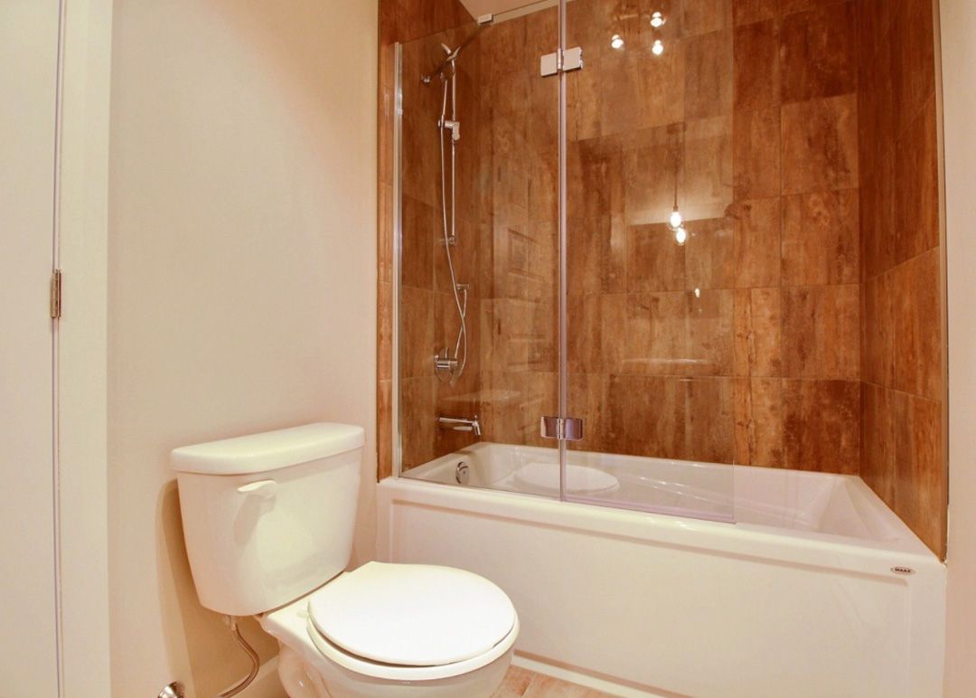 Une salle de bain avec WC, baignoire et douche.