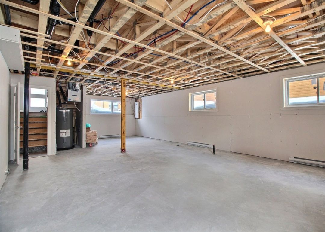 Un sous-sol vide avec un plafond en bois et un sol en béton.