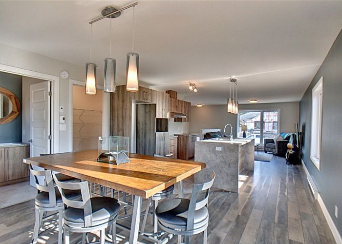 Une salle à manger avec une table et des chaises en bois dans une maison.