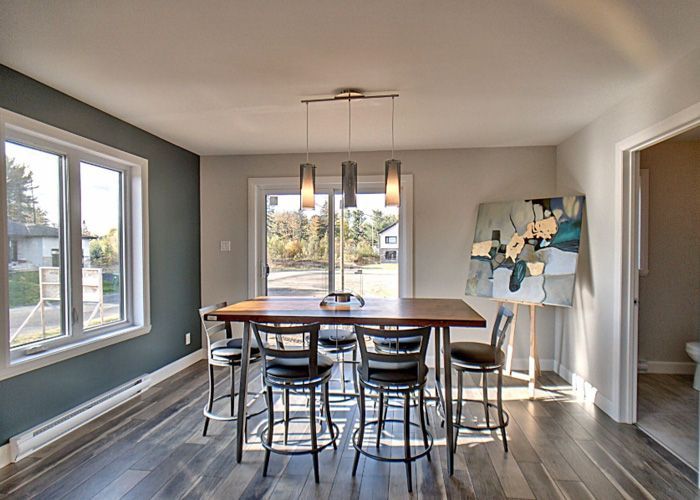Une salle à manger avec une table et des chaises et un tableau au mur.