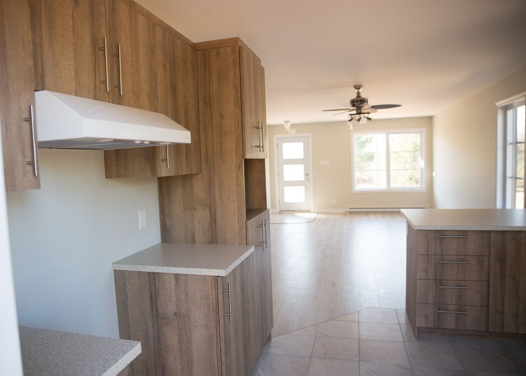 Une cuisine avec des armoires en bois et un ventilateur de plafond