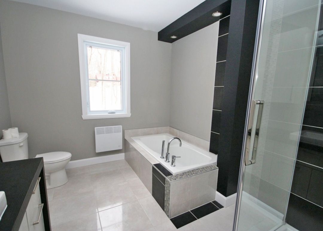 Une salle de bain avec baignoire, toilettes et douche.