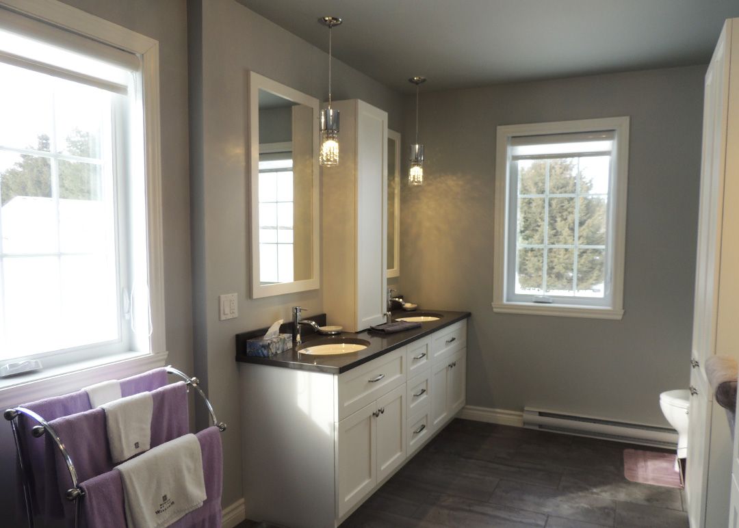 Une salle de bain avec deux lavabos et deux miroirs