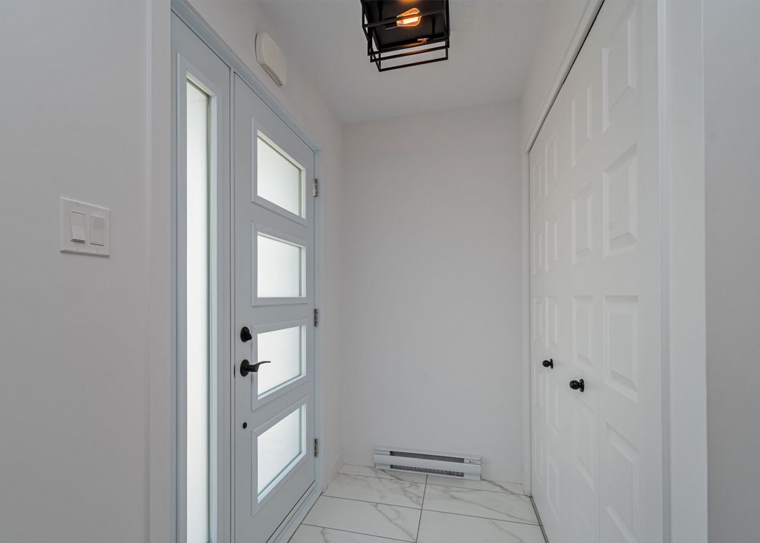 Un couloir avec une porte et une lumière au plafond.