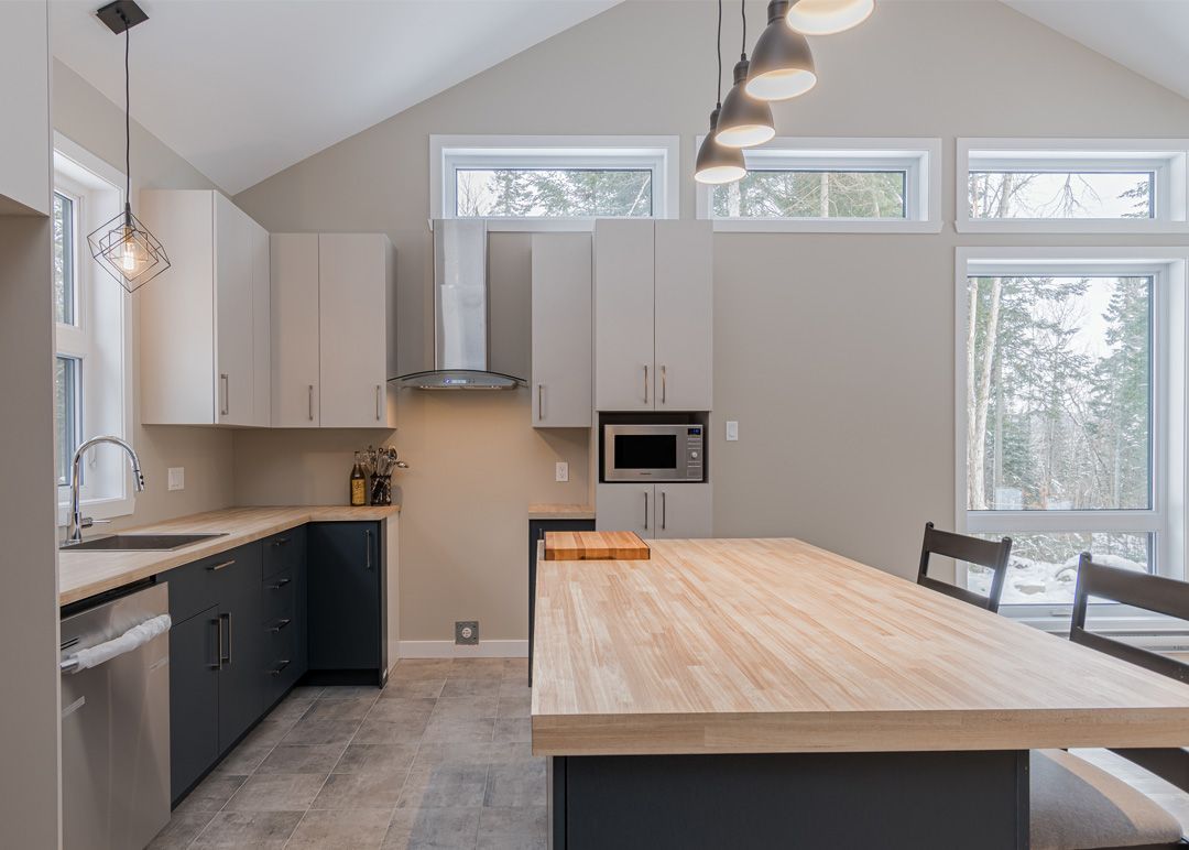 Une cuisine avec une grande table en bois et des appareils électroménagers en acier inoxydable.