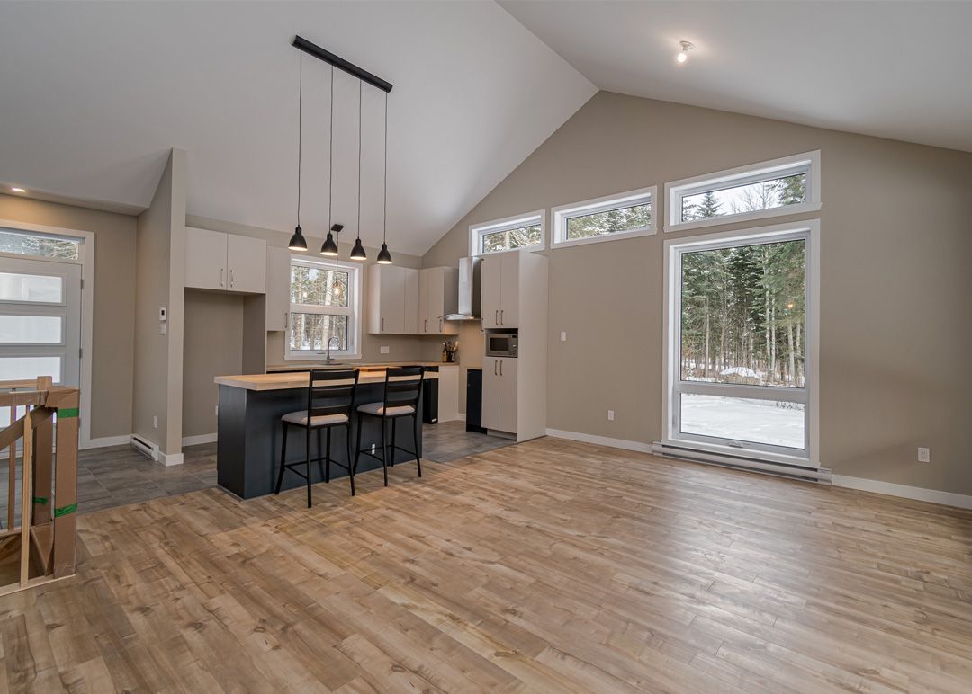 Une cuisine dans une maison avec du parquet et un plafond voûté.