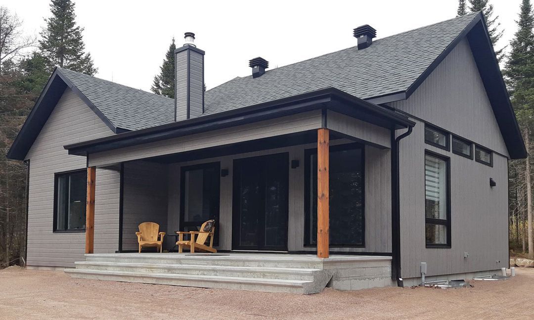 Une petite maison avec un porche et des chaises dessus
