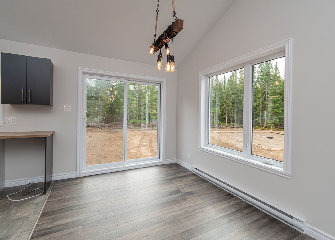 Une pièce vide avec beaucoup de fenêtres et un plancher en bois.
