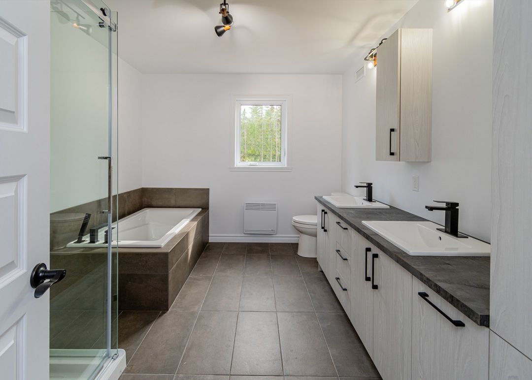 Une salle de bain avec baignoire, lavabo, toilettes et fenêtre