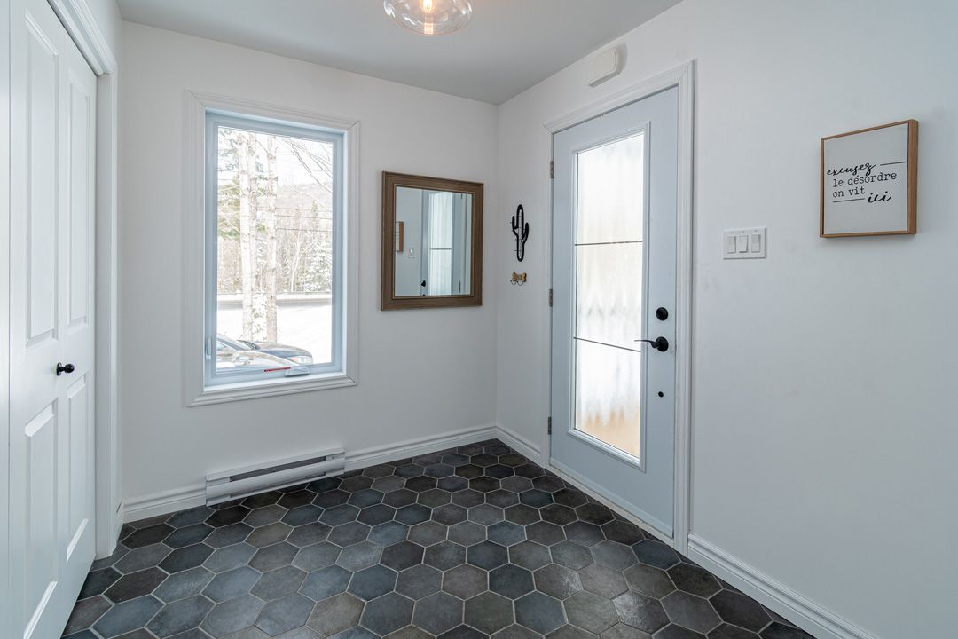 Un couloir avec une porte et un miroir dans une maison.