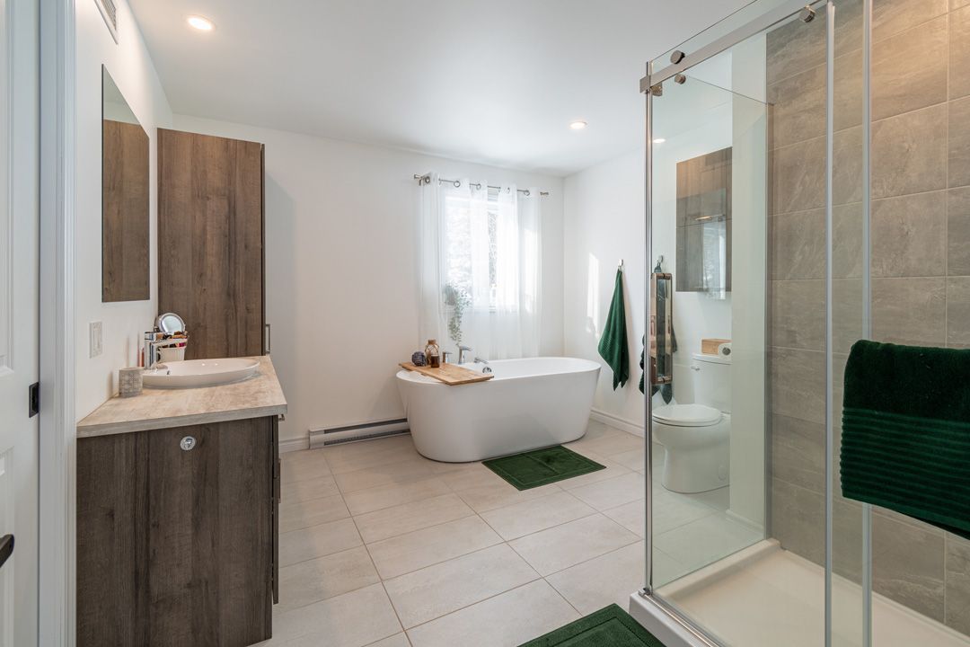 Une salle de bain avec baignoire, lavabo, WC et douche.