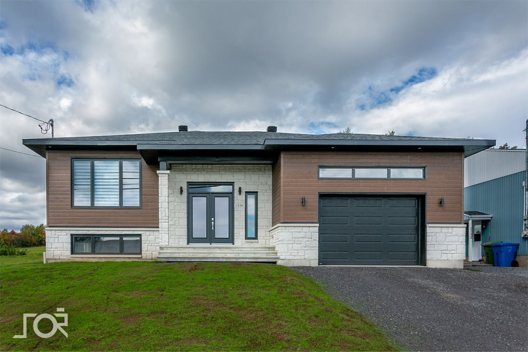 Une maison avec un garage et beaucoup de fenêtres