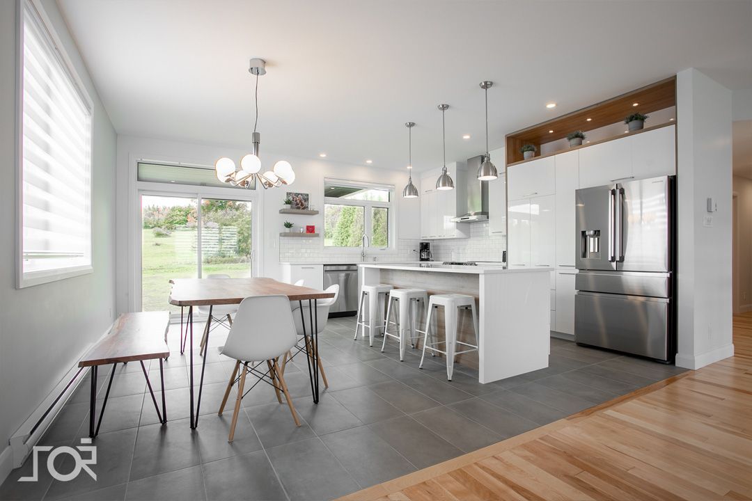 Une cuisine avec une table et des chaises et un réfrigérateur.
