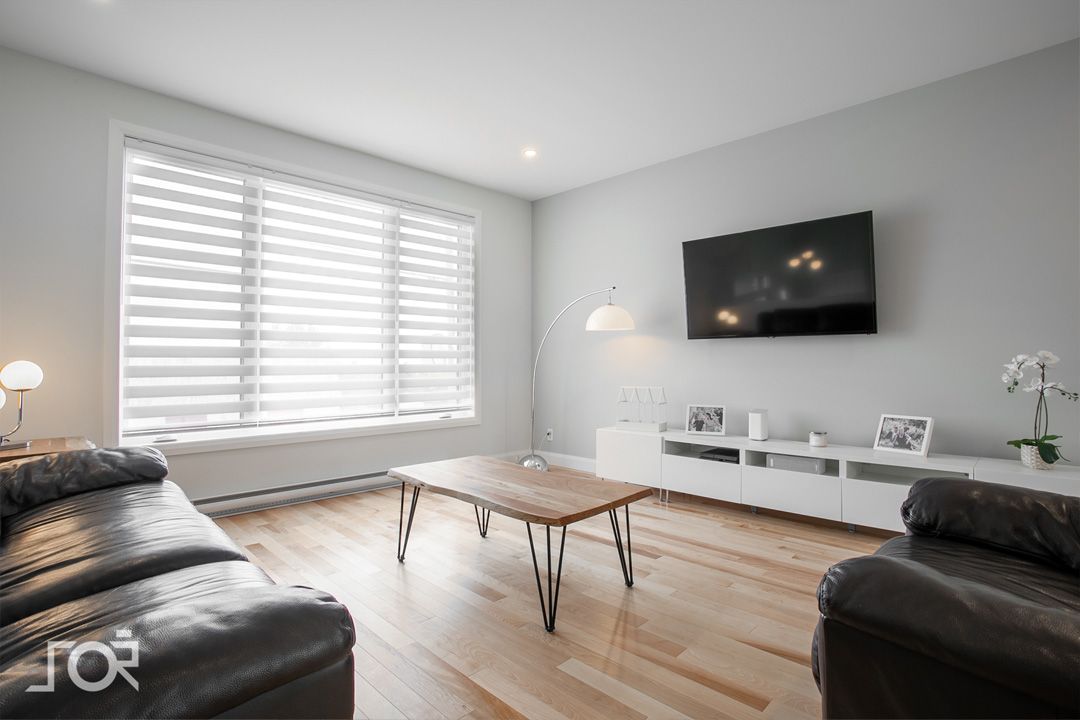 Un salon avec un canapé, une chaise, une table basse et une télévision.