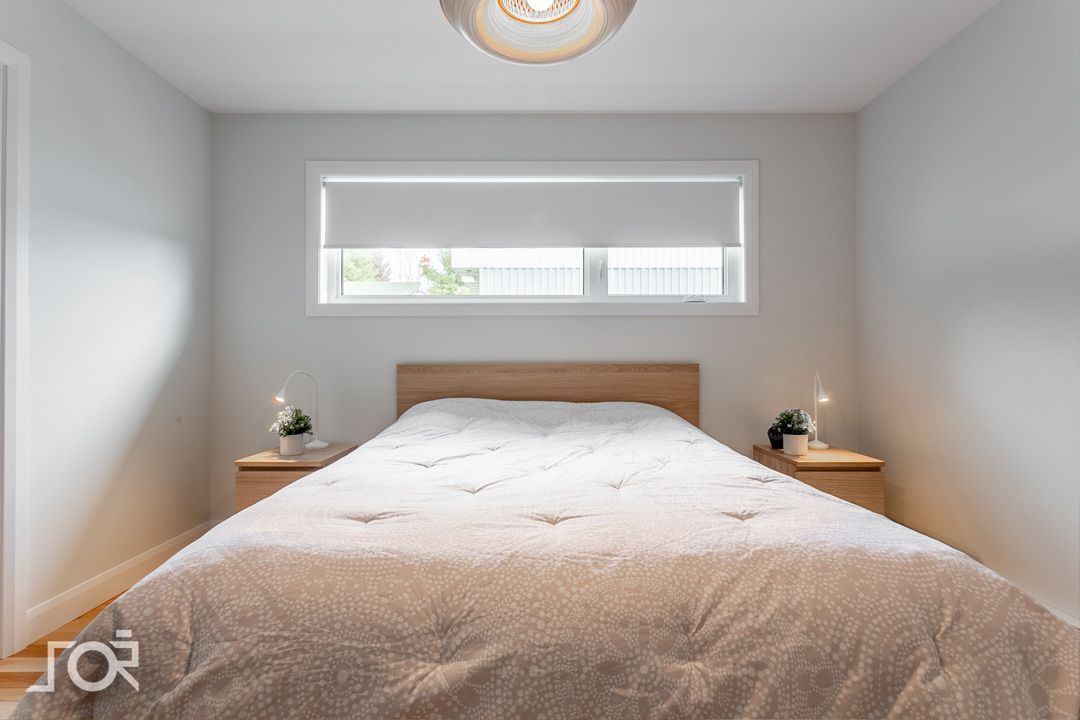 Une chambre avec un lit, des tables de nuit et une fenêtre.