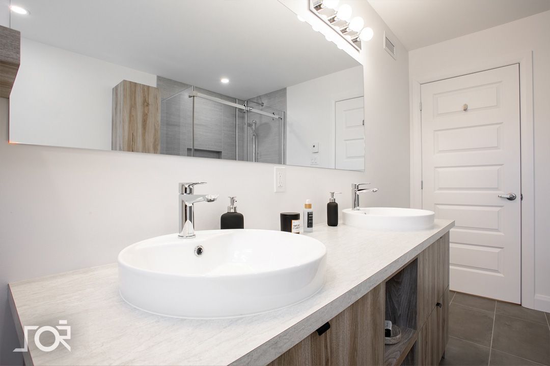 Une salle de bain avec deux lavabos et un grand miroir.