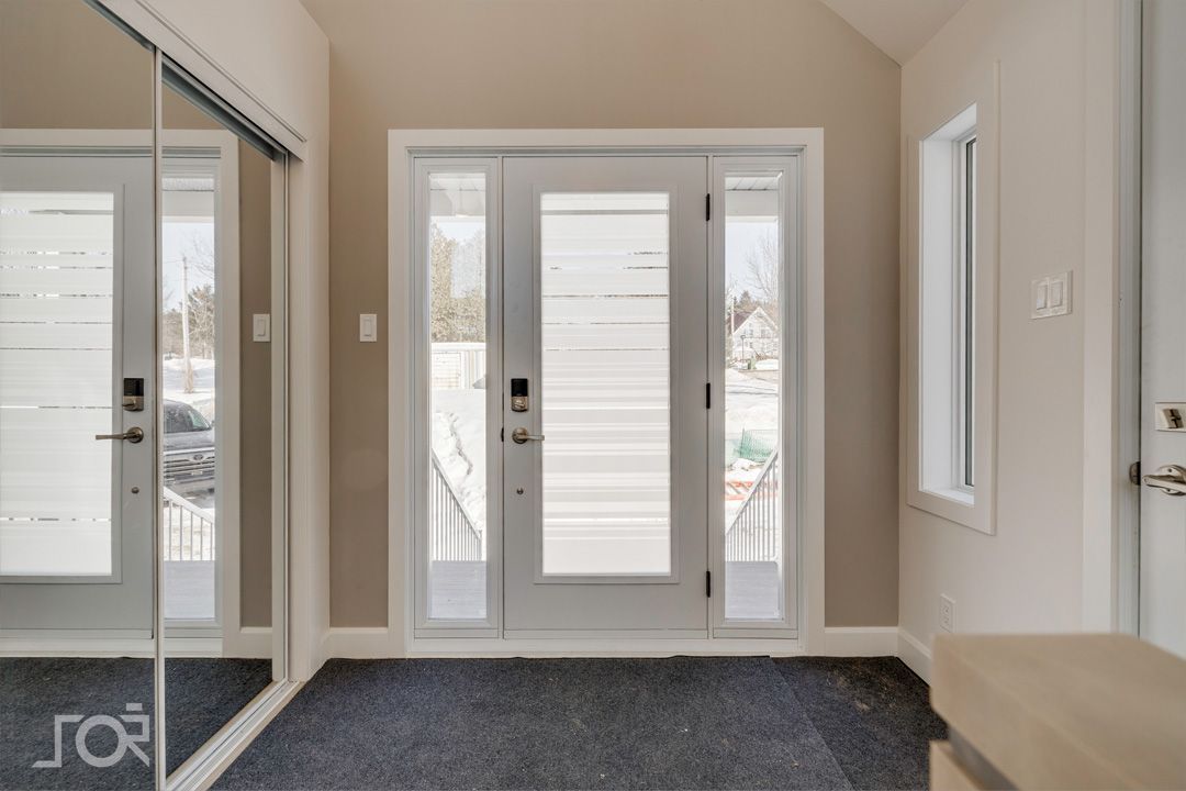 Une pièce vide avec une porte et un miroir.