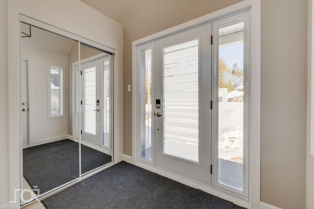 Un couloir avec des portes coulissantes en verre et des miroirs