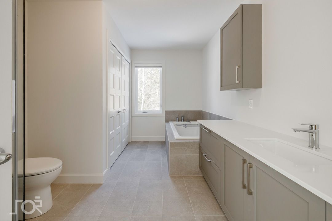 Une salle de bain avec WC, lavabo et baignoire.