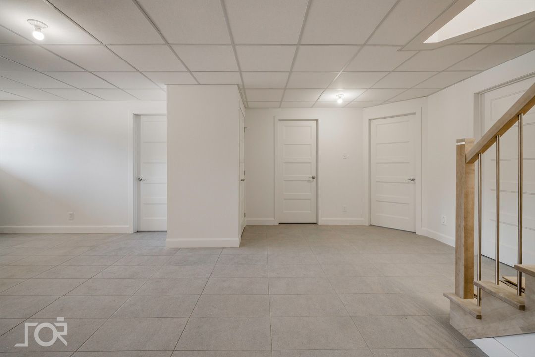 Un sous-sol vide avec des escaliers menant au deuxième étage