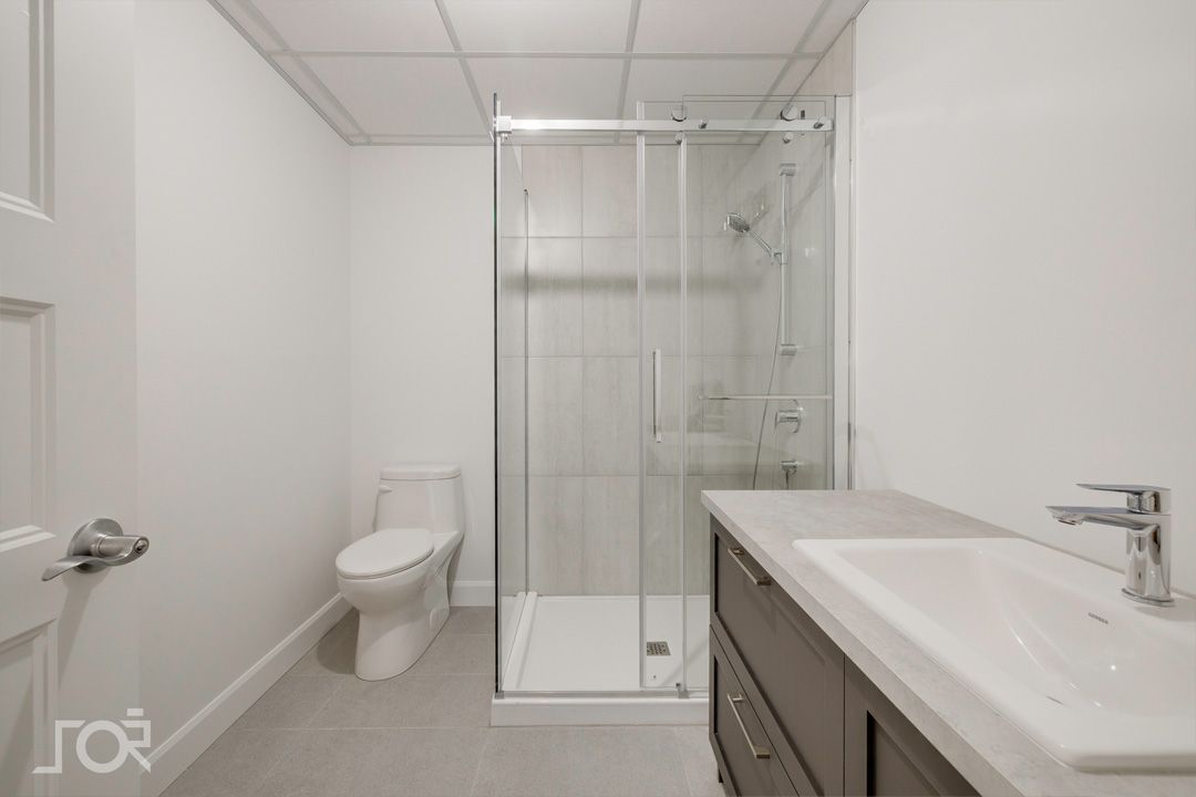 Une salle de bain avec WC, lavabo et douche.