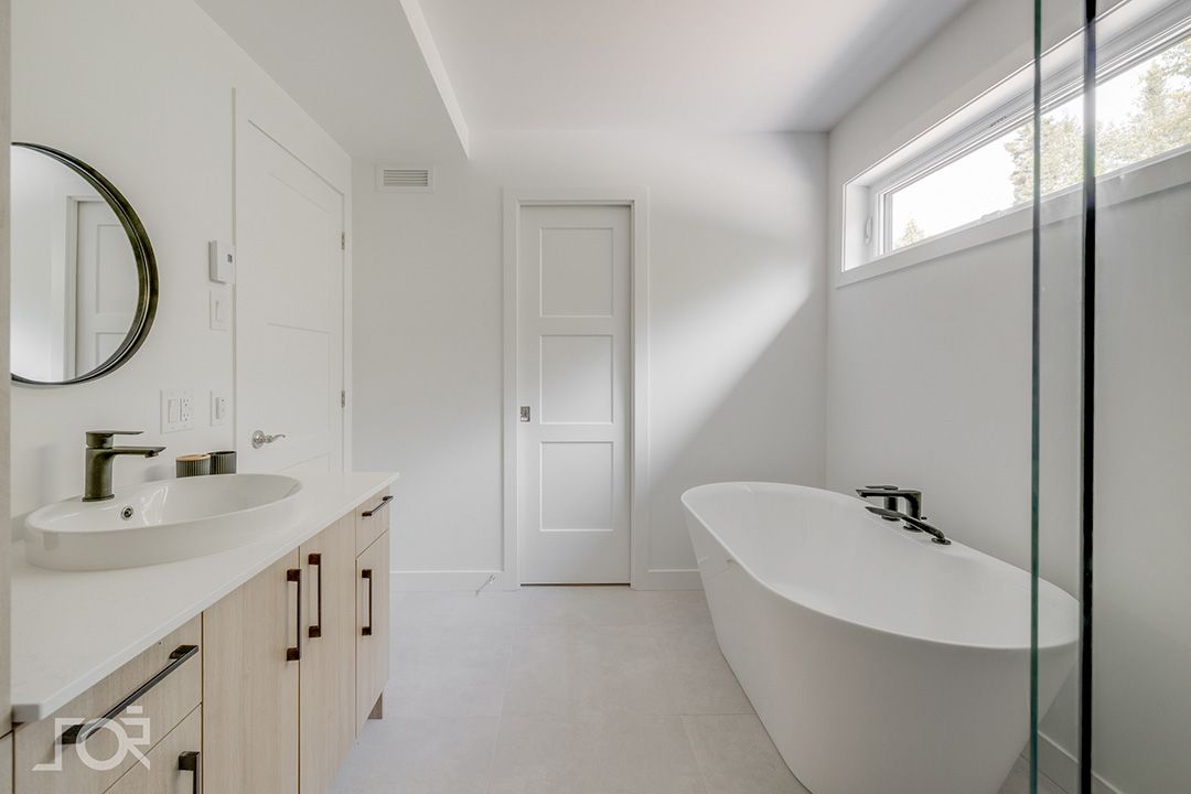 Une salle de bain avec baignoire, lavabo et miroir.