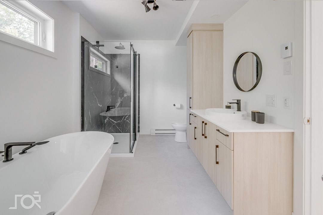 Une salle de bain avec baignoire, lavabo, WC et douche.