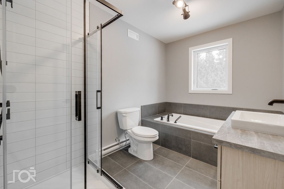 Une salle de bain avec WC, lavabo, baignoire et douche.