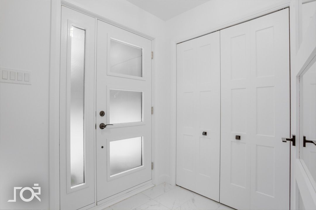 Un couloir blanc avec une porte et des placards