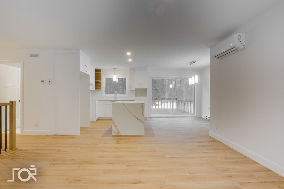 Une pièce vide avec du parquet et des murs blancs