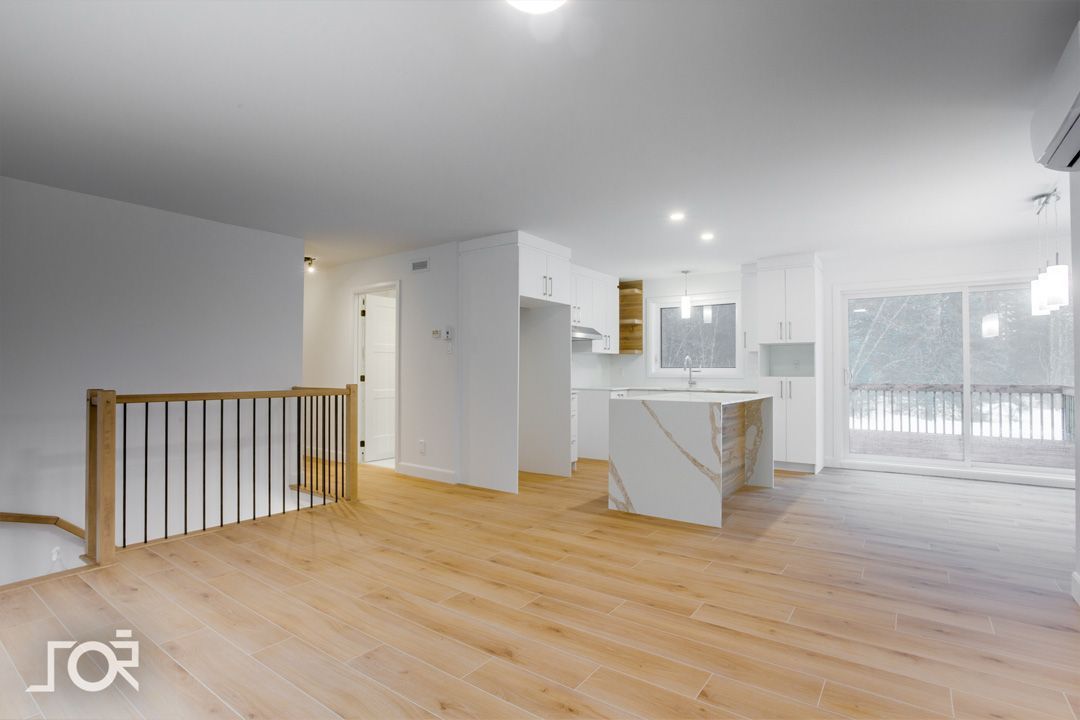 Une pièce vide avec du parquet et des murs blancs