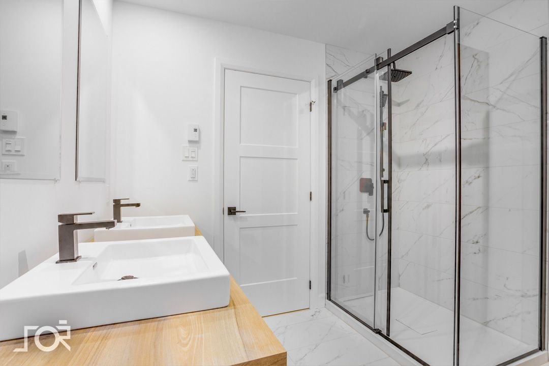 Une salle de bain avec deux vasques et une douche à l'italienne.