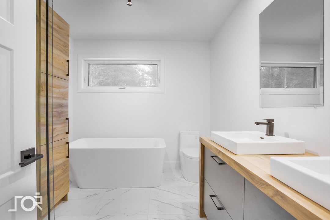 Une salle de bain avec deux lavabos et une baignoire