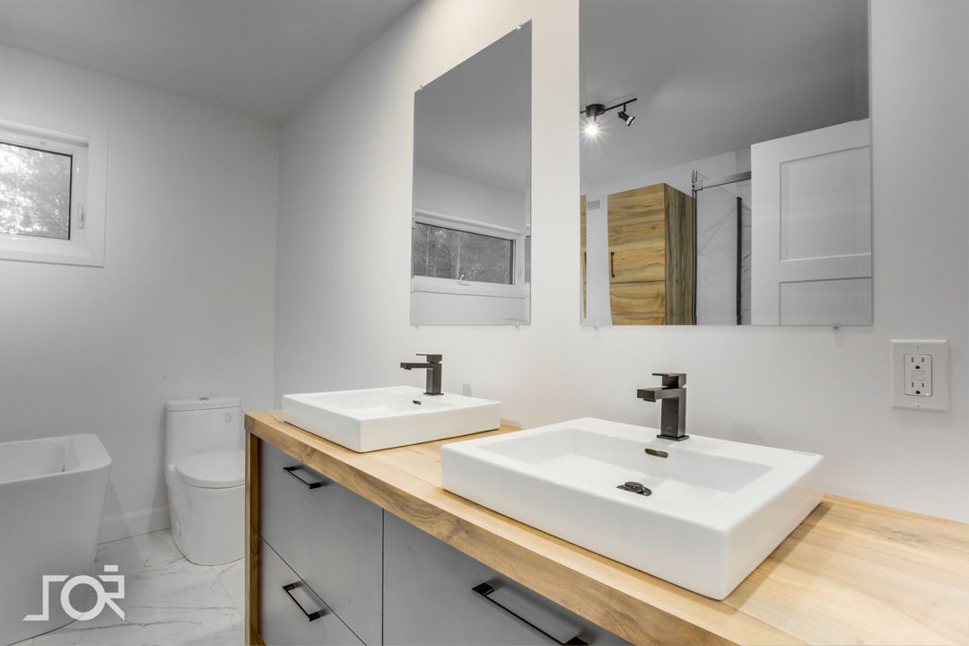 Une salle de bain avec deux lavabos et deux miroirs