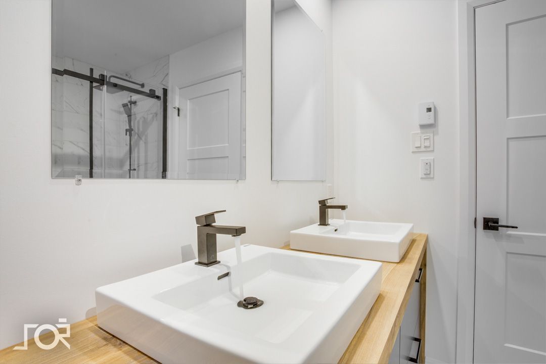 Une salle de bain avec deux lavabos et un miroir.