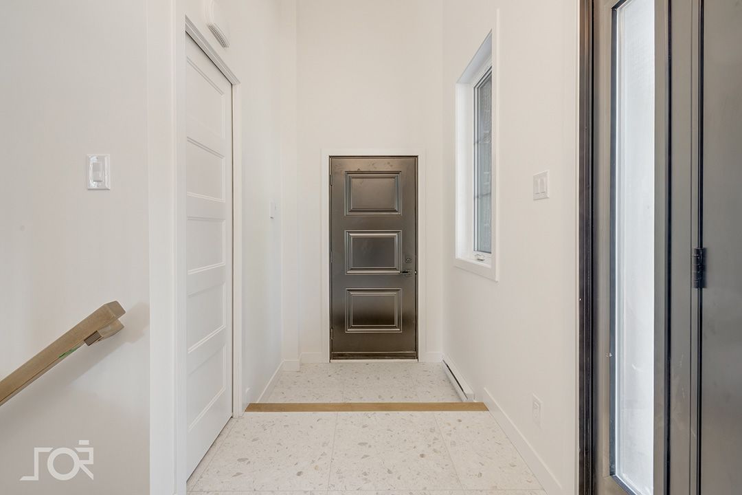 Un couloir avec une porte et une fenêtre dans une maison.