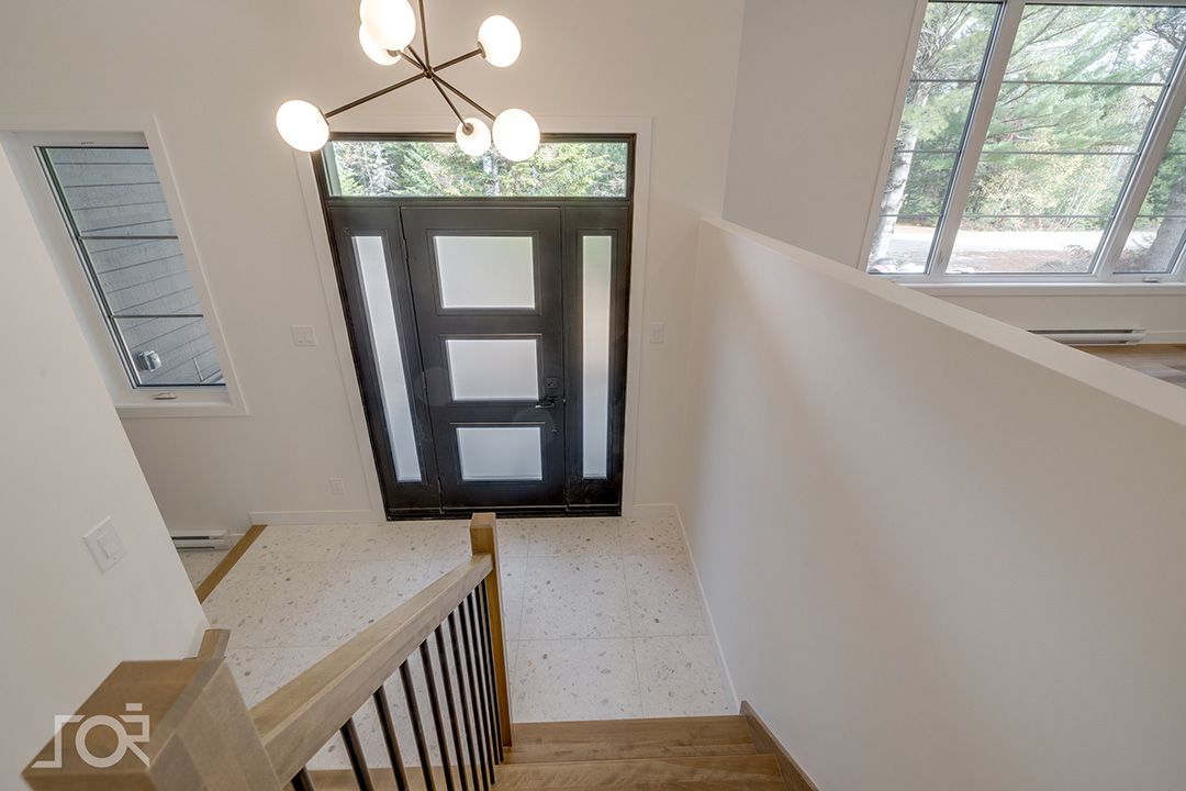 Une vue d'un escalier menant à une porte dans une maison.