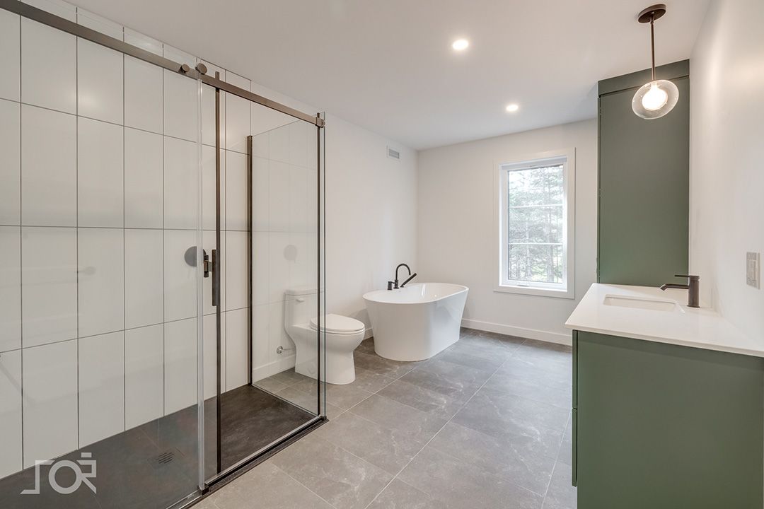 Une salle de bain avec baignoire, WC, lavabo et douche.