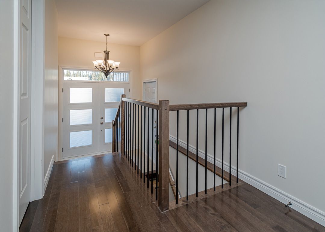 Un couloir avec un escalier menant au deuxième étage d'une maison.