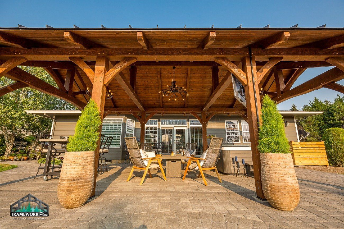 A wooden pavilion with a table and chairs underneath it.